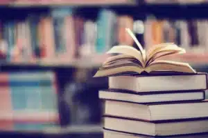 pile de livres avec un livre ouvert sur le dessus etageres d
